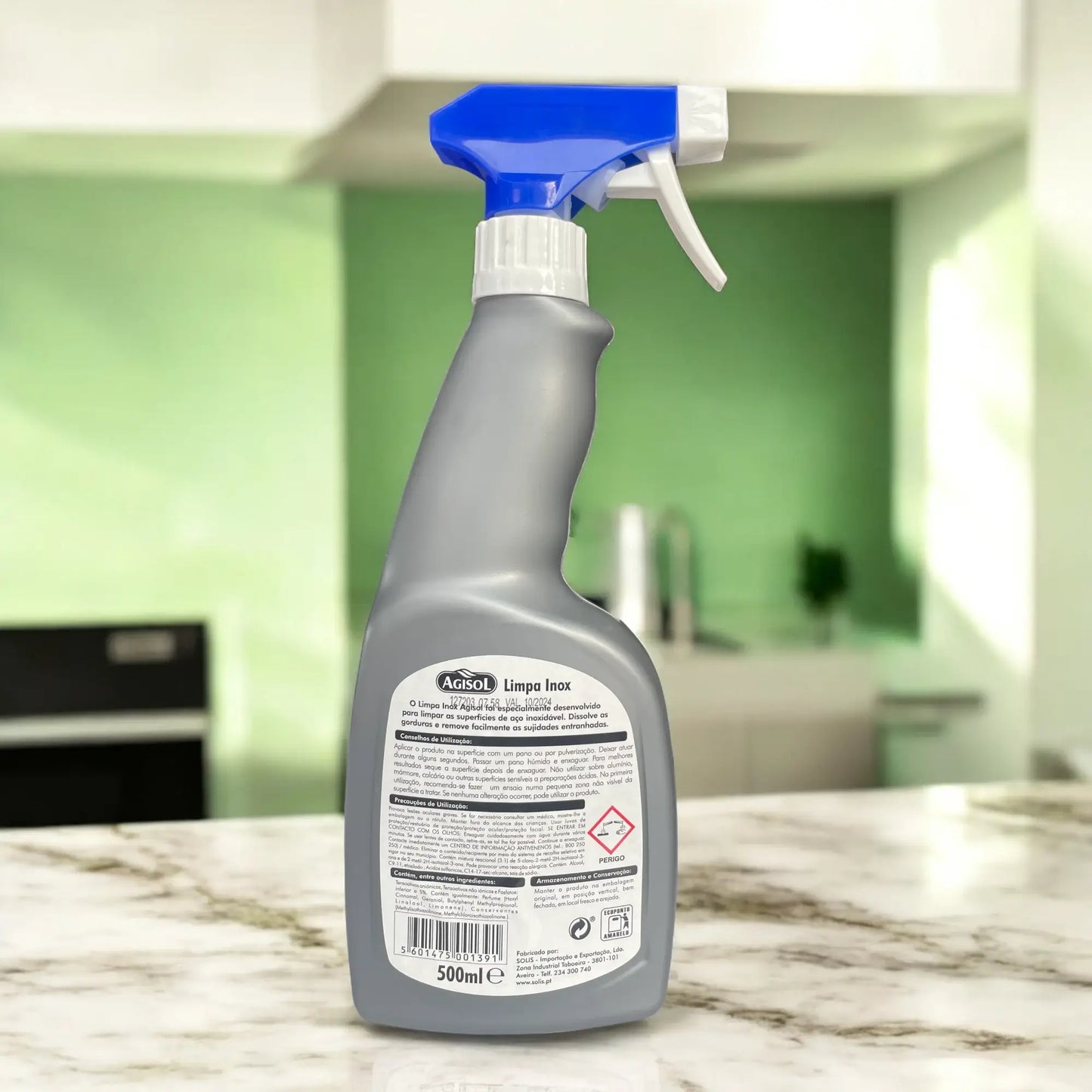 Vista de trás de embalagem de detergente para superfícies de aço inox numa cozinha